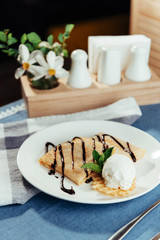 Pancakes with ice cream and chocolate sauce.