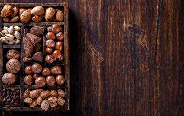 Nuts Mixed in a Wooden Vintage Box.Assortment, Walnuts,Pecan,Peanuts,Almonds,Hazelnuts,Macadamia,Cashews,Pistachios.Concept of Healthy Eating.Vegetarian.Copy space.selective focus.