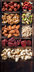 Nuts Mixed in a Wooden Vintage Box.Assortment, Walnuts,Pecan,Peanuts,Almonds,Hazelnuts,Macadamia,Cashews,Pistachios.Concept of Healthy Eating.Vegetarian.selective focus.