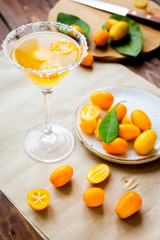 cocktail with kumquat on wooden background