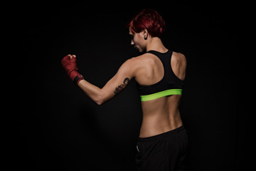 Fototapeta na wymiar Boxing woman with red boxing wraps on black background