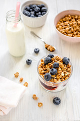 Fitness breakfast with granola, milk and berries on white background