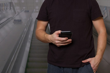 Mann schreibt auf der Rollte ins Smartphone