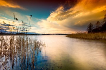 Colorful sunset sky over lake in long exposure landscape - obrazy, fototapety, plakaty