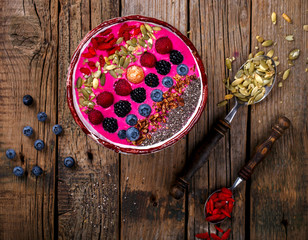 Berry Smoothie in the  bowl on a wooden Vintage Background.Detox. Breakfast Pudding topped with goji berries, and chia seeds.Concept of Healthy Food.Copy space. selective focus.