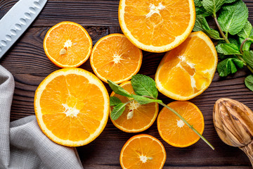 orange juice with mint squeezing on wooden kitchen background top view