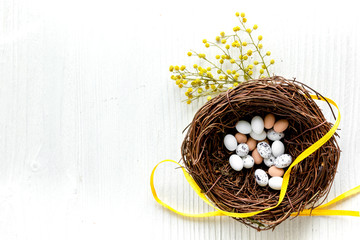 Easter eggs in nest on white background top view mock up
