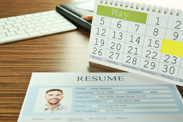 Obraz premium Calendar with job interview reminder and resume on wooden table