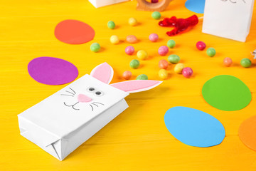 Easter decorative bunny bag with candies on wooden background