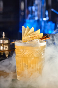 long alcoholic cocktail of apples and cinnamon in smoke