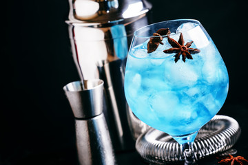 Alcoholic cocktail with sambuca, liqueur, lemon juice, crushed ice and stars of anise, black...
