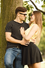 Couple hugging under tree.