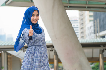 Beautiful woman dress arabic smile and thumbs up with in city.