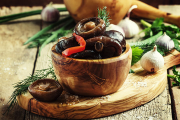 Marinated shiitake mushrooms, vintage wooden background, selective focus