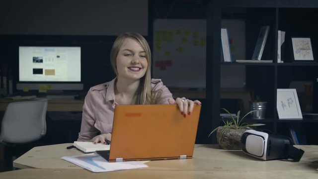 Young woman finishes work in office