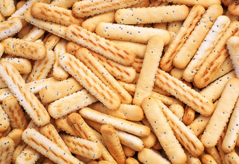 Bread sticks with poppy seeds as background