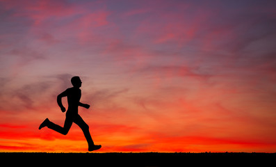 Silhouette of running man on sunset fiery sky background