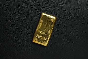 The gold bar put on the dark surface background scene represent gold and business finance concept related idea.