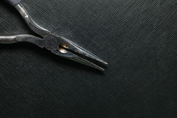 The old and dirty long nose pliers represent the tool and equipment concept related idea.
