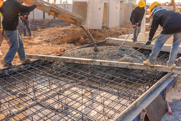 Concrete pouring during commercial concreting floors of buildings in construction site.