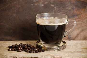Cup of hot coffee with roasted coffee bean on wooden background
