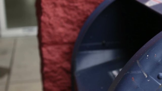Man delivers envelope into mailbox near supermarket   Close up