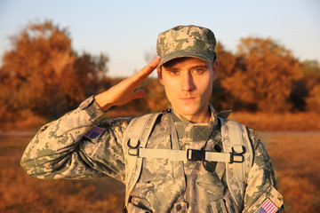 Soldier in camouflage taking salute outdoors