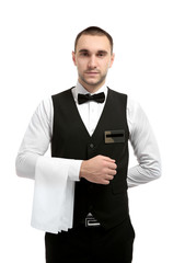 Young handsome waiter with napkin standing on white background