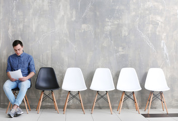 Young man waiting for job interview in hall