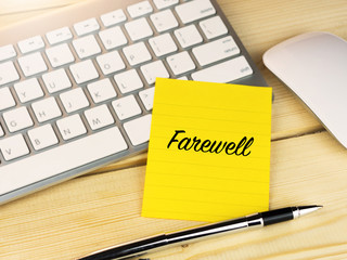 Farewell on sticky note on work desk table, resignation office life concept
