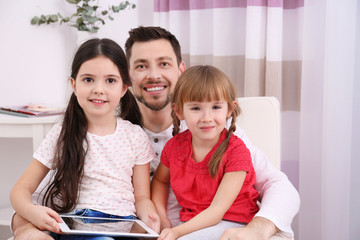 Father with daughters on sofa in the room