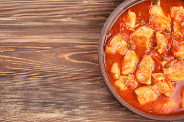 Chicken tikka masala in wooden bowl, closeup