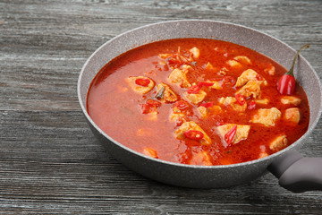 Chicken tikka masala in pan on grey wooden table