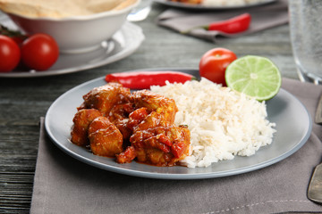 Portion of chicken tikka masala with rice on grey plate