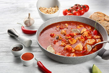 Chicken tikka masala in pan on white wooden table