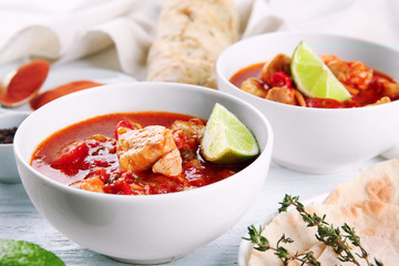 Portions of chicken tikka masala on white wooden table