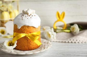 Decorative plate with Easter cake on wooden table