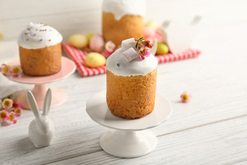 Stands with Easter cakes on wooden table