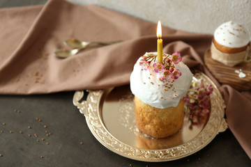 Easter cake with lighted candle on metal tray