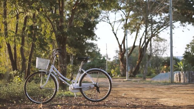 Vintage style bicycle at fall season road in Asian country with sunset light
