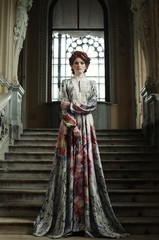 woman in elegant dress posing on stairs