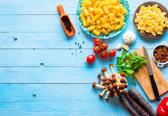Top view of italian ingredients for spaghetti, over a wood background.