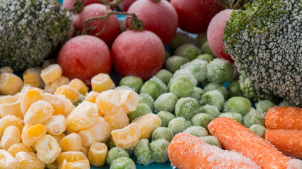 frozen vegetables: broccoli, cherry tomatoes, corn, pea, carrot on blue plate - 137283067