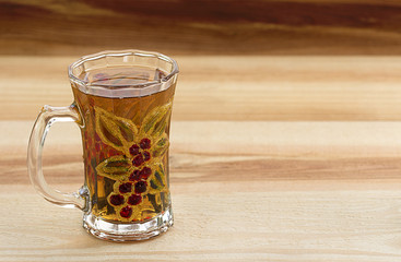 Glass cup of tea on wooden background
