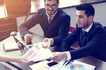 two young businessmen working on laptop at  modern office.
