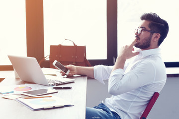 young hipster businessman working on laptop at modern office.