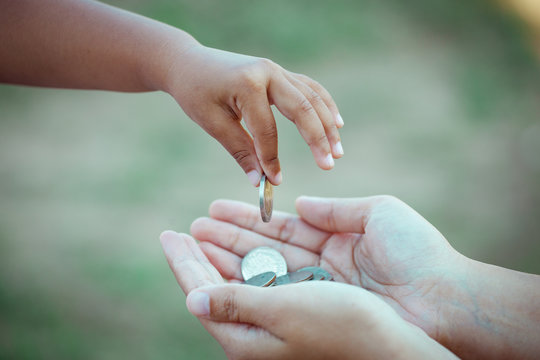 child little girl giving coin to mother as saving money concept in vintage color tone