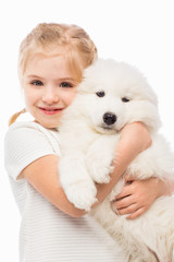 Little girl with a samoyed puppy