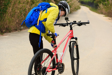 young woman ready to riding mountain bike on forest trail