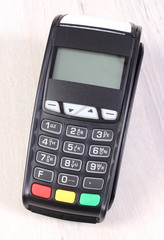 Obraz premium Payment terminal, credit card reader on wooden background, cashless paying for shopping, finance concept